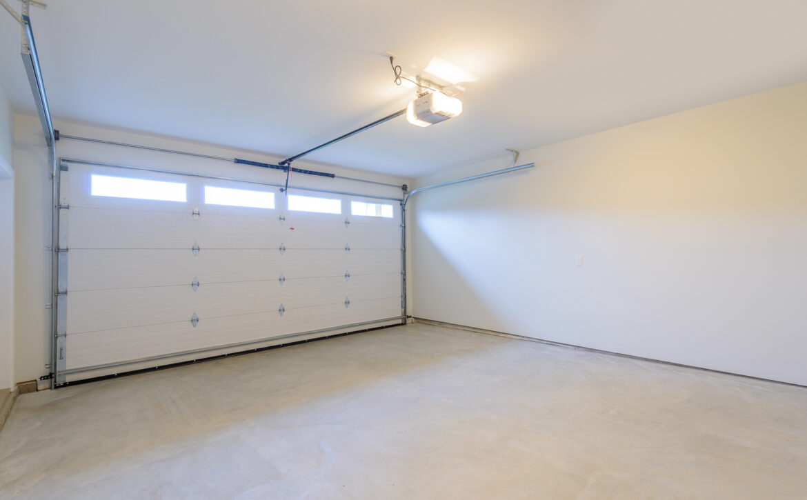 An empty garage with door and windows.