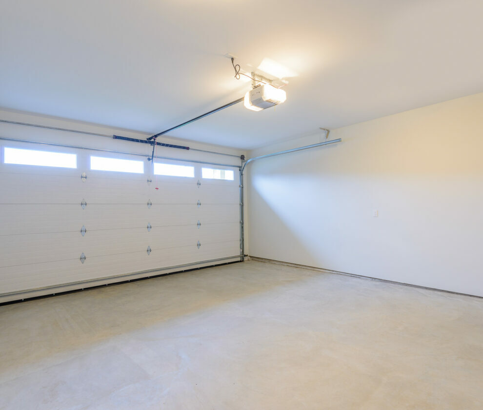 An empty garage with door and windows.